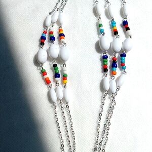 NEW.  MULTI-COLORED GLASS BEADS WITH LARGE WHITE BEADS TO OFFSET CLUSTERS.  52"